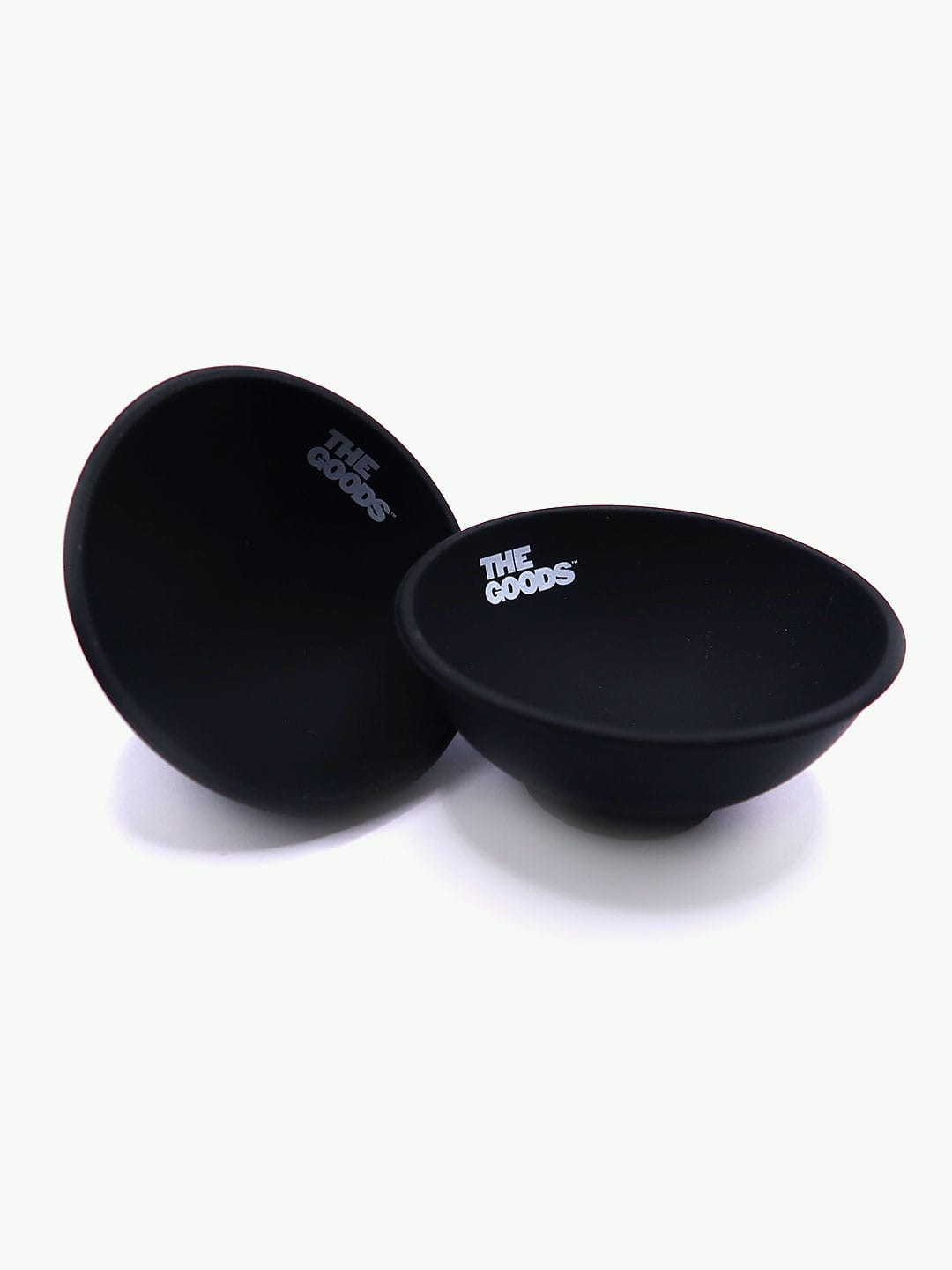 Two The Goods Black Silicone Bowls by The Goods sit on white, ideal as portable rolling trays.