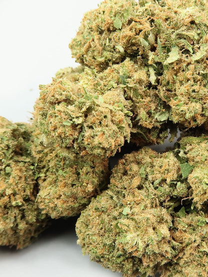 Close-up of HempElf “Zkittlez” CBD Hemp Flowers (8-13%) with trichomes and green leaves on a white background.